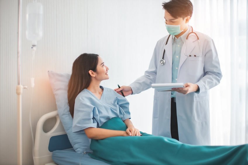 Hospitalist physician talking to a patient in the hospital 