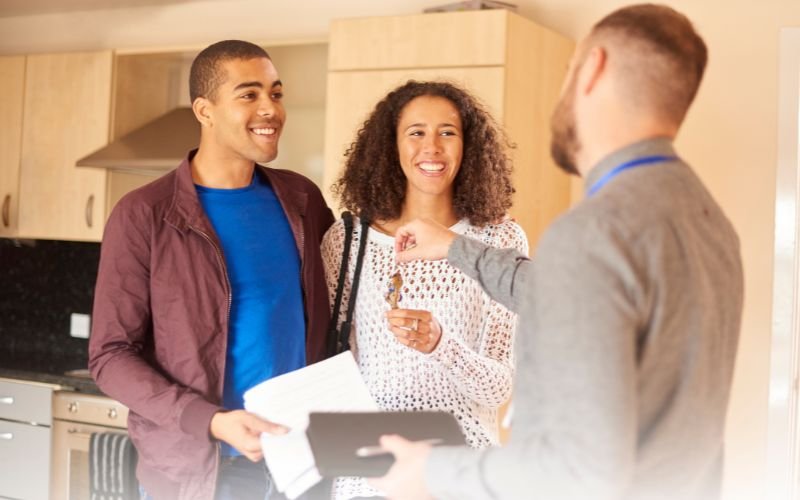 Property manager giving keys to new tenants