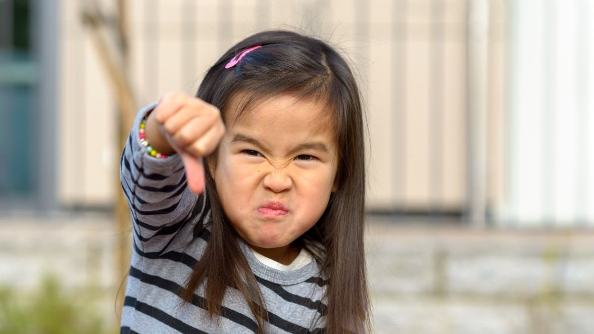 Image of angry child giving a thumbs down