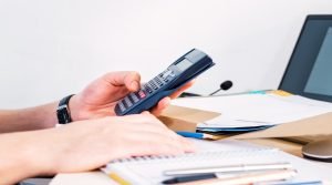 Businessman doing calculating and accounting with a calculator on the desktop in the office